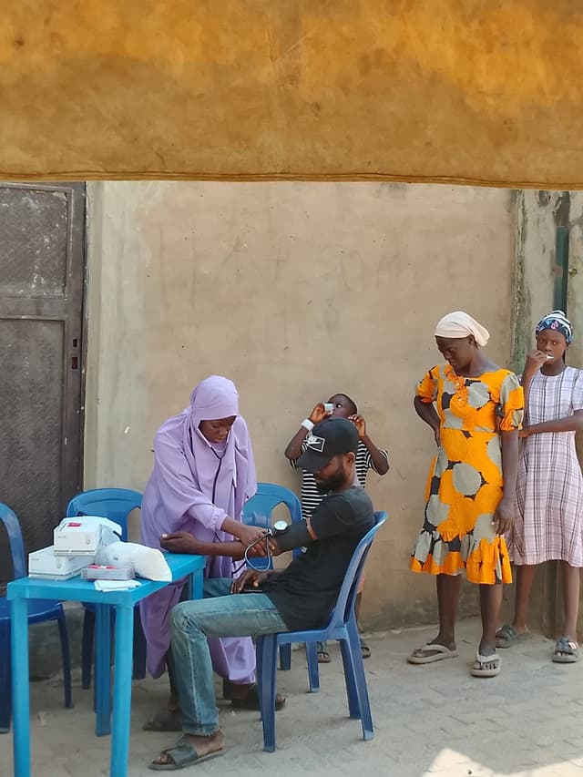 Blood pressure check with family members observing