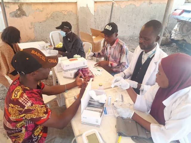 Multi-person testing table with health workers