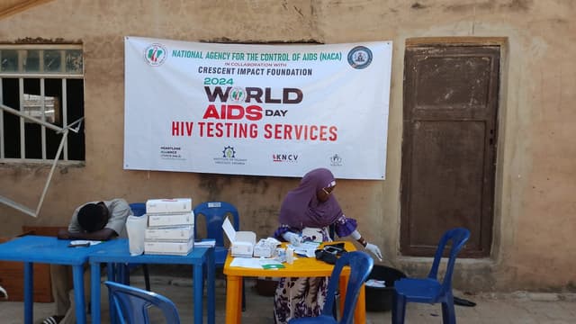 Outreach banner mounted at worksite wall, worker at table